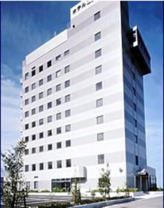 泉佐野新裕酒店的一座高大的白色建筑,上面有标志