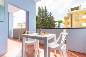 阿尔巴·阿德里亚蒂卡Appartamento Turchese - MyHo Casa的小阳台配有白色的桌子和白色的椅子