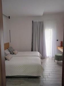 LakkíonBianco Hotel的一间卧室设有一张大床和一个窗户。