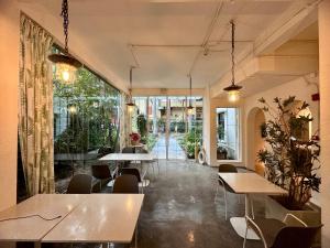 深圳深圳侨城旅友国际青年旅舍的餐厅设有桌椅和大窗户。