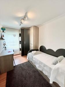 艾利亚德亚罗萨Apartamento Praia Naval的一间卧室配有两张床和一张书桌