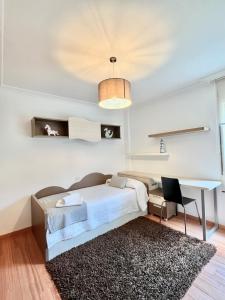 艾利亚德亚罗萨Apartamento Praia Naval的一间卧室配有一张床和一张书桌