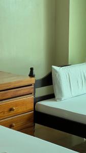 TagumInside Room Inn的一间卧室配有一张床和一个木制梳妆台