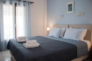新马尔马拉斯Glaros Blue的一间卧室配有带毛巾的床