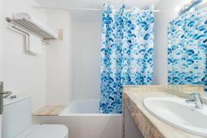 卡拉博纳Aparthotel Ferrer Lime Isabel的浴室设有蓝色的浴帘和水槽