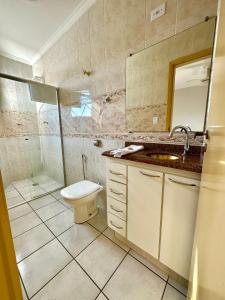 阿瓜斯-迪圣佩德罗Apartamento 32 no centro de Águas de São Pedro的浴室配有卫生间、淋浴和盥洗盆。