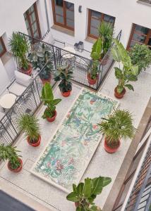 格拉纳达Seda Club Hotel - Small Luxury Hotels的阳台配有桌子、盆栽植物和地毯