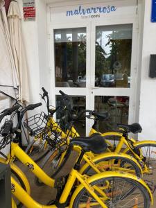 瓦伦西亚玛尔瓦洛萨海滩旅馆的停在商店前的一组黄色自行车