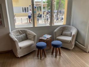 瓦伦西亚玛尔瓦洛萨海滩旅馆的一间设有两把椅子、一张桌子和两张凳子的房间