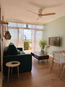 拉皮内达Apartamento Boutique en la Playa的客厅配有绿色沙发和桌子
