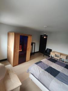 特镇Gîte et Chambres d'hôte L'Amarante的一间卧室配有一张床和一个木制橱柜