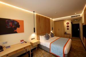 内罗毕PrideInn Westlands Luxury Boutique Hotel的配有一张床和一张书桌的酒店客房