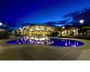 达沃市Verdon Parc Condo 1 Bedroom的一座大型建筑,在晚上前设有一个游泳池