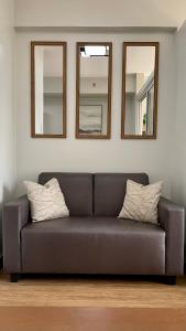 达沃市Verdon Parc Condo 1 Bedroom的客厅的沙发,配有三面镜子