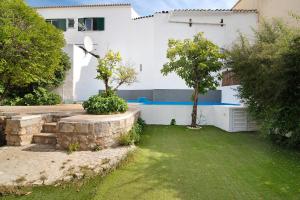 埃斯托伊Casa da Peixa的一座白色的房子,前面有一座树木的院子