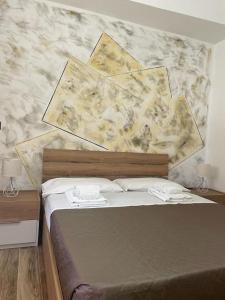 圣欧费米亚拉默齐亚B&BUrszula Gizzeria Lido的卧室内的一张床铺,设有大理石墙