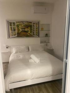 罗马Exclusive Mood Apartment的卧室内的一张带两个枕头的白色床
