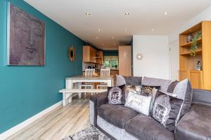 Tranquillity Suites Warrington 1bed Wifi Sleeps 4的客厅设有棕色沙发和蓝色的墙壁。