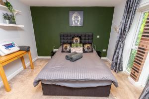 Tranquillity Suites Warrington 1bed Wifi Sleeps 4的一间卧室设有一张床和绿色的墙壁