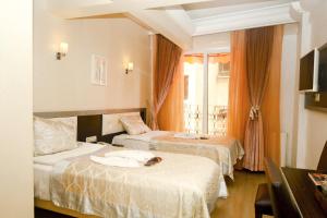 伊斯坦布尔Pearl Hotel İstanbul的酒店客房设有两张床和窗户。