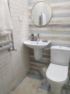 苏姆盖特Novxani jorat beach area的一间带卫生间、水槽和镜子的浴室