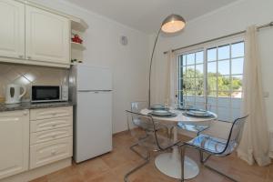 卡巴纳斯·德·塔维拉Casa Oceanus - 2BDR House w Pool & Balcony的厨房配有桌子和白色冰箱。