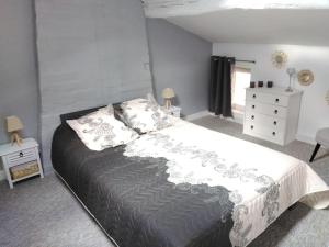 圣布里斯德斯布伊Gîte des Bujours的一间卧室配有一张大床和一个梳妆台