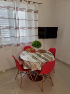 布雷拉Apartmani BELVEDERE的一张带红色椅子的餐桌和一台电视