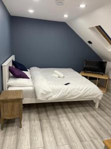 伦敦EAST LONDON APARTMENTS SELF check in的卧室配有白色的床和蓝色的墙壁