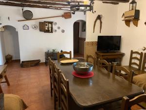 卡斯特里尔Casas Rurales Cortijo Cerro Fuentes Nuevas的一间带木桌和椅子的用餐室