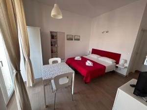 维拉诺瓦Casa Petrolla 126的一间卧室配有红色的床和一张桌子