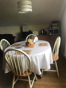多尼戈尔Meadow House in County Donegal的餐桌、白色桌布和两把椅子