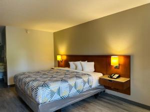 福雷斯特城Motel 6 Forrest City AR的酒店客房配有一张床和电话