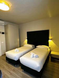卡沃PFA Hotel - Isola d'Elba的配有白色床单的酒店客房内的两张床