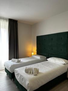 卡沃PFA Hotel - Isola d'Elba的两张位于酒店客房的床,配有毛巾