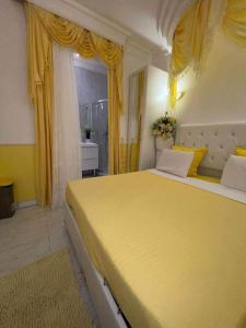 Deuil-la-BarreChambre de luxe 95 Grise的一间卧室配有黄色窗帘的大黄床