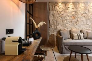萨索斯尼科拉塔豪华别墅酒店的带沙发和石墙的客厅