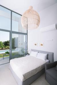 PetroúlaiSevene Villas的一间卧室配有一张大床和一个吊灯。