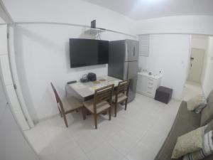 弗洛里亚诺波利斯Ap no centro de Florianopolis的厨房配有桌椅和电视。