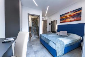 圣塔马利奈拉BNB Aria di Mare的一间卧室配有蓝色的床和一张书桌