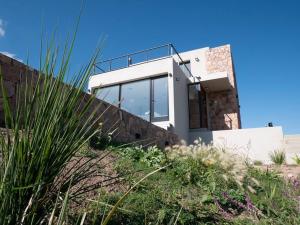 拉库布蕾Casa en la naturaleza con vistas a las Sierras的白色的房子,设有玻璃窗和栅栏