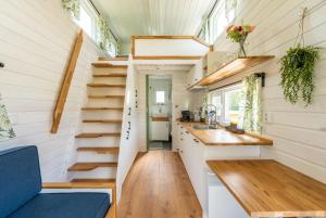 泽沃德Green Tiny House with shared pool的一个小房子,设有楼梯和厨房