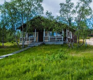 LeppäjärviTunturikeskus Galdotieva的一座带门廊和草地庭院的小房子