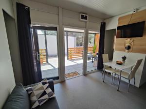 德拉格ARIA Mobile Home, Oaza Mira 5 Star Camping, Dalmatia的一间带桌椅的客厅和一个阳台