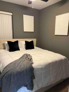 芝加哥Neutral Spiraled Vibes的卧室配有一张带黑色枕头的大型白色床。