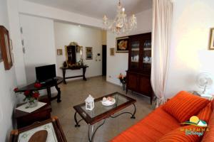 福洛尼卡Maremma Holidays : Fiore Apartment的客厅配有橙色沙发和桌子