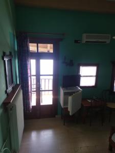 桑加拉达Double studio room in Mylopotamos with beautifull view的一间设有绿色墙壁的客房和一扇带窗户的门