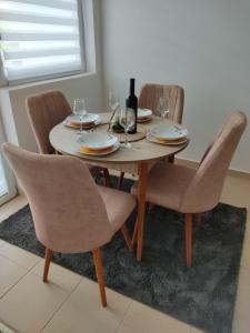 普卢日内Apartman Andjela的餐桌、椅子和一瓶葡萄酒