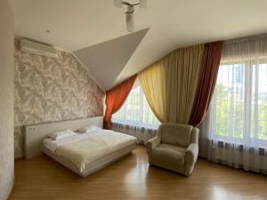 切尔诺夫策Parus的一间卧室配有一张床、一把椅子和窗户。