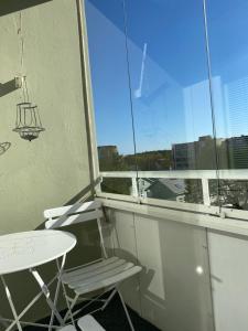 图尔库City apartment Pikkuvuori的阳台配有桌子、椅子和窗户。